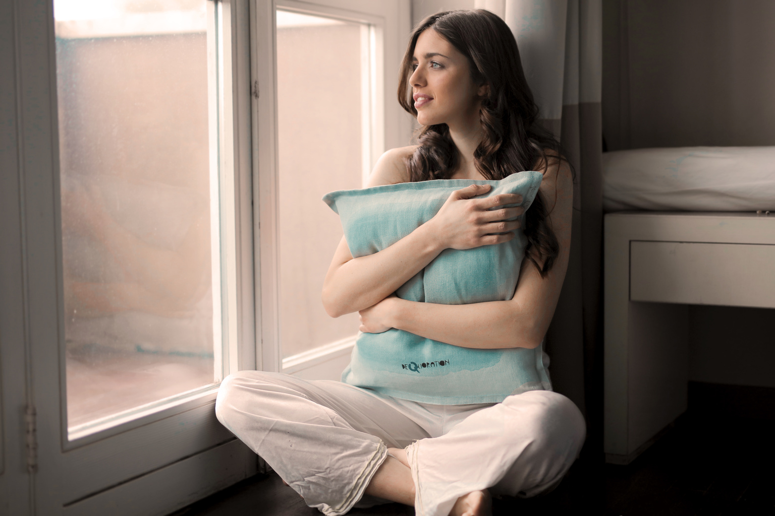 Woman Hugging a Teal Pillow